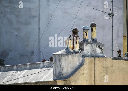 Petits pots de cheminée méditerranéens avec différents chapeaux ressemblant à un village miniature sur le toit d'un immeuble traditionnel dans la ville de Banque D'Images
