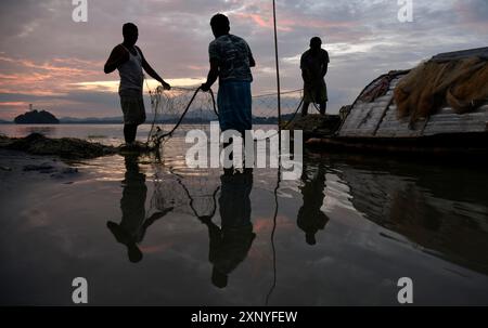 Pêcheurs nettoyant leurs filets de pêche après avoir pêché dans la rivière Brahmapoutre, à Guwahati, Assam, Inde, le mercredi 09 octobre 2019 Banque D'Images