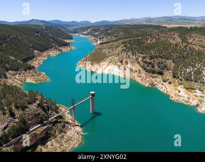 Une rivière avec un petit pont ou barrage entouré de montagnes boisées et de rives rocheuses, vue aérienne, réservoir, Embalse de Francisco Abellan, Fardes Banque D'Images