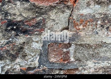 Un ancien mur de pierre européen forme une plaque de fond texturée intéressante Banque D'Images