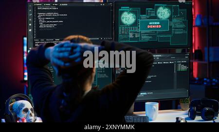 Hacker dans un appartement caché essayant de voler des données précieuses en ciblant des sites Web gouvernementaux, mais obtenant l'accès refusé message d'erreur, ayant les cyberattaques rejetées, caméra A. Banque D'Images