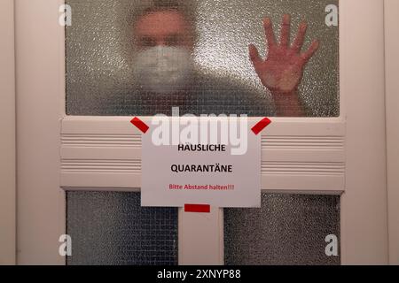 Image symbolique quarantaine domestique, l'homme est en isolement à la maison en raison d'une infection corona suspectée, signe d'avertissement pour les visiteurs sur la porte d'entrée Banque D'Images