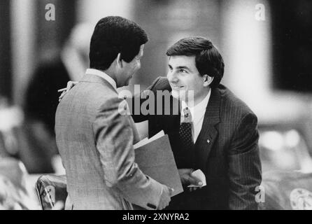 Austin Texas USA, 1991 : le représentant de l'État MIKE TOOMEY (à droite) s'entretient avec le représentant de l'État hispanique HUGO BERLANGA sur le sol de la chambre de la Chambre des représentants du Texas pendant la session législative du Texas. ©Bob Daemmrich Banque D'Images