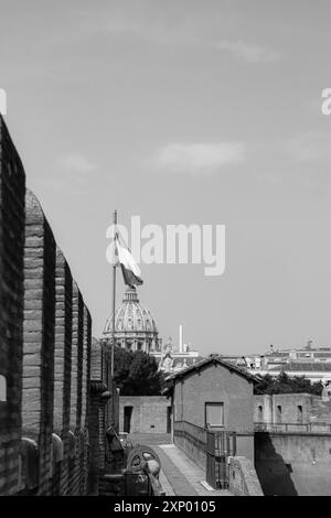 La basilique Pierre au Vatican vue depuis le musée Castel Sant'Angelo comme drapeau italien ouvert au vent en noir et blanc Banque D'Images