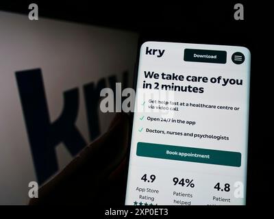 Stuttgart, Allemagne, 03-30-2022, personne tenant un téléphone portable avec la page web de la société suédoise de soins de santé Kry International AB sur l'écran avec le logo. Mise au point Banque D'Images