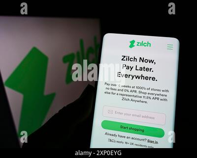 Stuttgart, Allemagne, 03-30-2022, personne tenant un téléphone portable avec le site de fintech Zilch Technology Limited (PayZilch) sur l'écran devant le logo. Banque D'Images