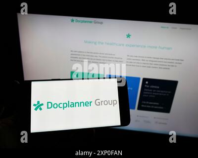 Stuttgart, Allemagne, 04-03-2022 : personne tenant un smartphone avec le logo de la société de soins de santé polonaise DocPlanner Group sur l'écran devant le site Web. Banque D'Images