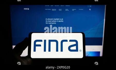 Stuttgart, Allemagne, 03-05-2022 : personne tenant un smartphone avec le logo de la Financial Industry Regulatory Authority (FINRA) sur l'écran devant le site Web. Banque D'Images