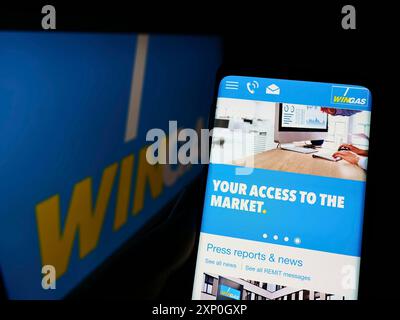 Personne tenant le smartphone avec la page Web de la société allemande de distribution de gaz Wingas GmbH sur l'écran devant le logo. Concentrez-vous sur le centre de l'écran du téléphone Banque D'Images