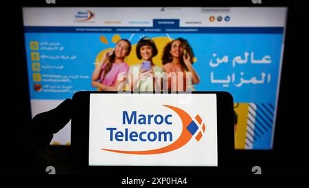 Stuttgart, Allemagne, 02-13-2022 : personne tenant un smartphone avec le logo de la société de télécommunications Maroc Telecom (IAM) sur l'écran devant le site Web. Banque D'Images