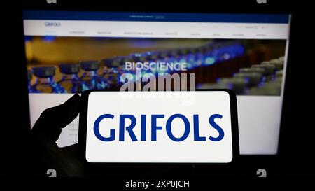 Stuttgart, Allemagne, 01-30-2022, personne tenant un téléphone portable avec le logo de la société pharmaceutique espagnole Grifols sa sur l'écran devant l'entreprise Banque D'Images