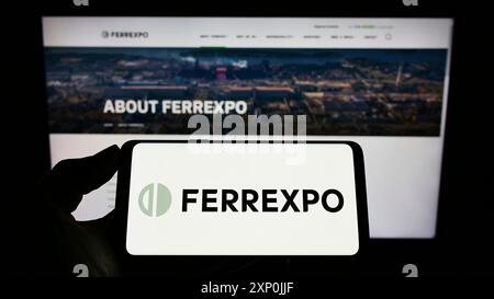 Stuttgart, Allemagne, 01-29-2022, personne tenant un téléphone portable avec le logo de la société suisse de négoce de marchandises Ferrexpo plc sur l'écran devant l'entreprise Banque D'Images