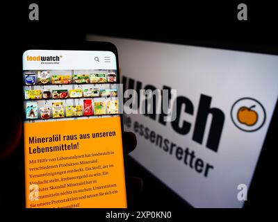 Stuttgart, Allemagne, 01-16-2022 : personne tenant un téléphone portable avec la page web du groupe allemand de défense Foodwatch e.V. sur l'écran devant le logo. Concentrez-vous sur Banque D'Images