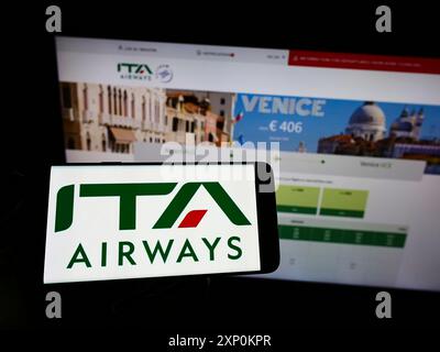 Stuttgart, Allemagne, 01-15-2022 : personne tenant un smartphone avec le logo de Airline Italia Trasporto Aereo S.p.A. (ITA Airways) sur l'écran devant Banque D'Images