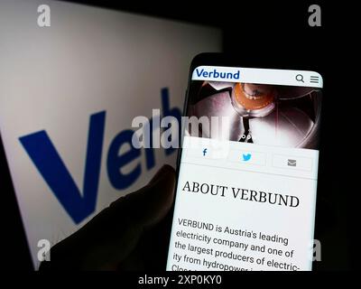 Stuttgart, Allemagne, 01-09-2022 : personne tenant un téléphone portable avec le logo de la compagnie d'électricité autrichienne Verbund AG sur l'écran devant le logo. Concentrez-vous sur Banque D'Images