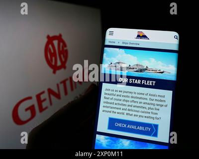 Stuttgart, Allemagne, 01-15-2022 : personne tenant un téléphone portable avec la page Web de l'entreprise Star Cruises sur l'écran avec le logo de la société Genting Hong Kong. Mise au point Banque D'Images