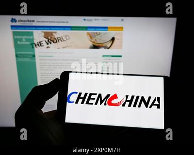 Stuttgart, Allemagne, 01-09-2022 : personne tenant un téléphone portable avec le logo de China National Chemical Corporation (ChemChina) sur l'écran devant la page Web. Banque D'Images