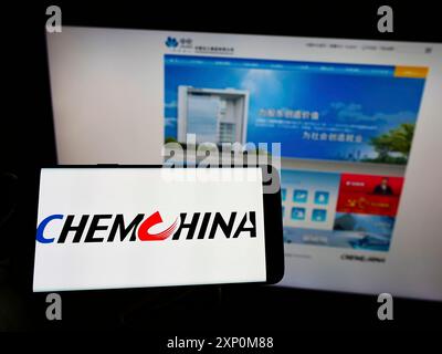 Stuttgart, Allemagne, 01-09-2022 : personne tenant un smartphone avec le logo de China National Chemical Corporation (ChemChina) sur l'écran devant le site Web. Banque D'Images