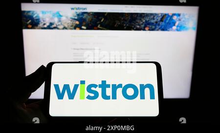 Stuttgart, Allemagne, 01-06-2022 : personne tenant un smartphone avec le logo de la société électronique taïwanaise Wistron Corporation sur l'écran devant Banque D'Images