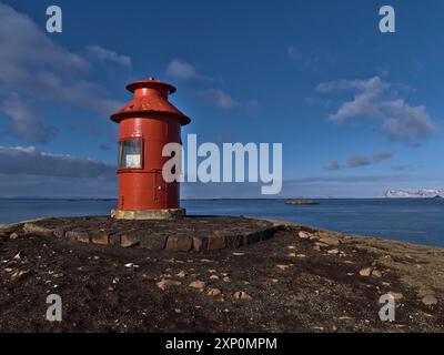 Belle vue du phare de Sugandisey de couleur rouge (construit en 1948) sur une île à Stykkisholmur, péninsule de Snaefellsnes, ouest de l'Islande en hiver Banque D'Images