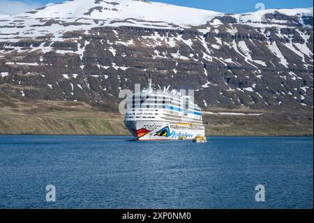 Aida Bella bateau de croisière au fjord de Seydisfjordur, Islande, vue de la distance avec des montagnes de neige en arrière-plan Banque D'Images