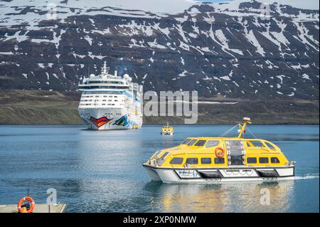 Aida Bella au fjord de Seydisfjordur avec deux canots de sauvetage jaunes devant et montagne de neige en arrière-plan, Islande Banque D'Images