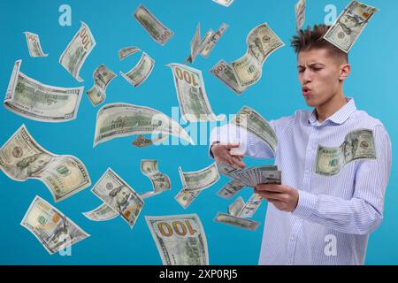 Homme jetant de l'argent sur fond bleu clair. Billets d'un dollar dans l'air Banque D'Images