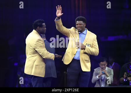 Canton, États-Unis. 02 août 2024. Le joueur du Pro Football Hall of Fame 2024, Andre Johnson (R), célèbre après avoir reçu sa veste en or du célèbre Michael Irvin. Lors de la cérémonie de la veste d'or à Canton, Ohio, le vendredi 2 août 2024. Photo de Aaron Josefczyk/UPI crédit : UPI/Alamy Live News Banque D'Images