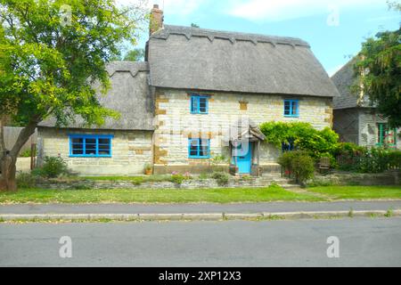 Maison de village Gaydon maisons de rue cottage chalets pub bar toit chaume chaume jolies fleurs plantes plante fleur style ancien paniers suspendus panier Banque D'Images