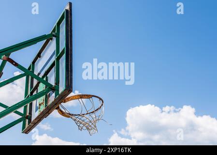 Vieux Hoop et Backboard en métal abandonné sur fond bleu ciel Banque D'Images