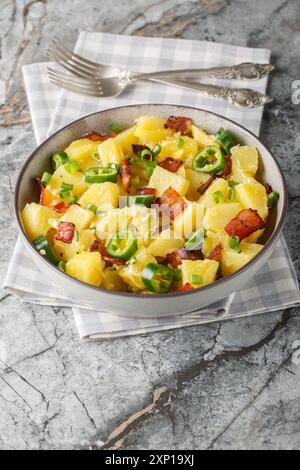 Salade de pommes de terre jalapeno avec bacon, oignons verts dans le style mexicain gros plan dans un bol sur la table. Vertical Banque D'Images