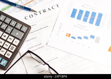 Sur la table de travail se trouvent une calculatrice, des lunettes, un stylo et des diagrammes. Vue de dessus gros plan concept d'entreprise Banque D'Images