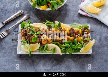 Agneau grillé, poivrons jaunes et brochettes de pommes de terre avec salade de feuilles vertes Banque D'Images