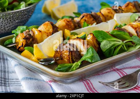 Agneau grillé, poivrons jaunes et brochettes de pommes de terre avec salade de feuilles vertes Banque D'Images