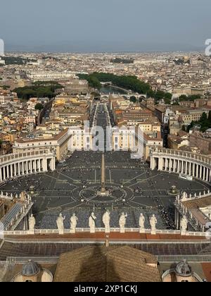 La ville de Rome est montrée d'en haut, avec une grande foule de personnes rassemblées dans le centre. L'atmosphère est animée et animée, avec des gens marchant Banque D'Images