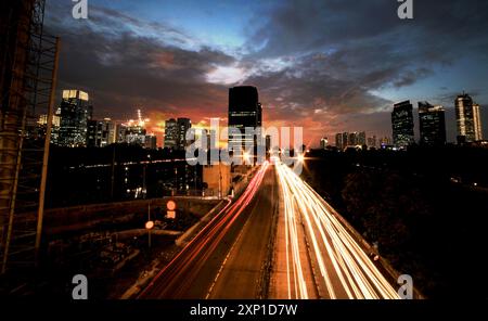 Sentiers légers dans la rue animée au coucher du soleil à Jakarta, Indonésie Banque D'Images