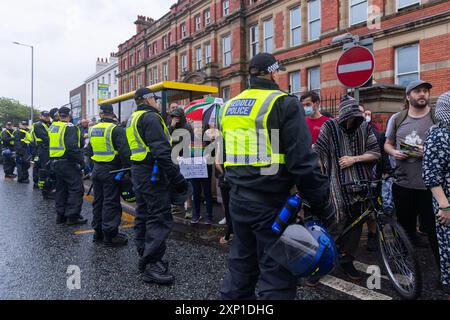 Liverpool, Royaume-Uni. 02 AOÛT 2024. Tentative de la police de séparer les deux camps, les manifestants s'identifiant comme étant de droite, ainsi que les membres du SUTR et des organisations de gauche se rassemblant sur les côtés opposés de la route à l'extérieur de la mosquée Abdullah Quilliam, l'une des premières mosquées d'Angleterre, dans un contexte d'émeutes à travers le pays suite à un incident à Southport. En dehors de quelques cris et des manifestants qui traversent brièvement les côtés, aucun problème n'a été observé. Crédit Milo Chandler/Alamy Live News Banque D'Images