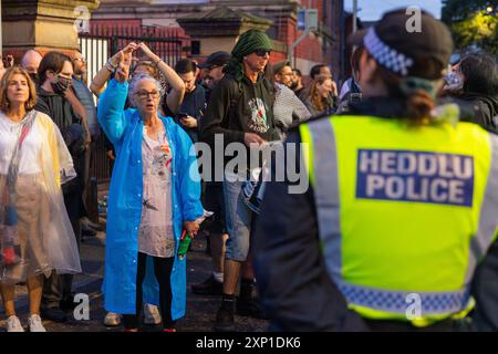 Liverpool, Royaume-Uni. 02 AOÛT 2024. Lady tient le signe de la paix alors que les manifestants s'identifient comme étant de droite, ainsi que des membres de SUTR et d'organisations de gauche rassemblés sur les côtés opposés de la route à l'extérieur de la mosquée Abdullah Quilliam, l'une des premières mosquées d'Angleterre, dans un contexte d'émeutes à travers le pays suite à un incident à Southport. En dehors de quelques cris et des manifestants qui traversent brièvement les côtés, aucun problème n'a été observé. Crédit Milo Chandler/Alamy Live News Banque D'Images