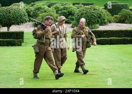 Trois hommes en uniforme britannique de la seconde Guerre mondiale marchant. Banque D'Images