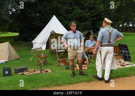 Quatre hommes en uniformes de la première Guerre mondiale devant des tentes. Banque D'Images