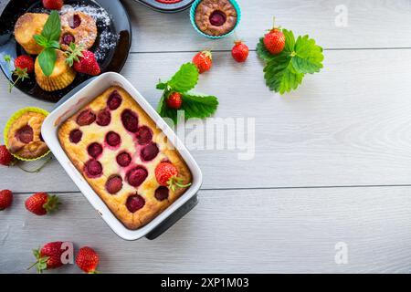 Cocotte au fromage cottage sucré avec garniture aux fraises, dans une assiette sur une table en bois. Banque D'Images