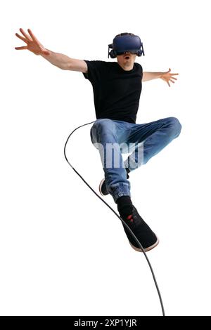 Jeune homme s'imagine un super-héros tout en utilisant des lunettes VR pour jouer à un jeu d'ordinateur. Portrait masculin sur fond blanc. Banque D'Images