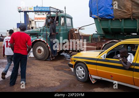 Une scène de personnes et de véhicules attendant de monter à bord du ferry de Banjul à Barra, Gambie, représentant la correspondance et le voyage. Banque D'Images