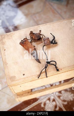 Gros plan des objets traditionnels de malédiction vaudou sur une surface en bois, représentant les pratiques mystiques et culturelles en Gambie. Banque D'Images