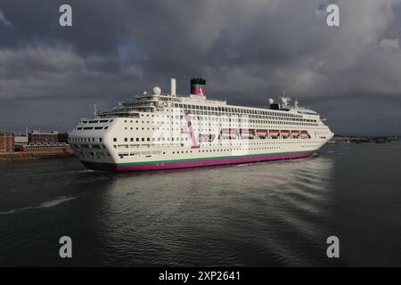 Le soleil tôt le matin et le ciel gris accueillent le navire à passagers Ambassador Cruise Line MS AMBIENCE à son arrivée dans le port Banque D'Images