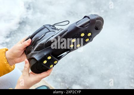 Galoches antidérapantes à clous portées sur la semelle des chaussures pour éviter de glisser et fournir une meilleure traction. Banque D'Images