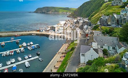 Gardenstown Aberdeenshire Écosse les murs du port amarraient les bateaux Seatown et Harbour Road et la mer bleu vert à marée haute en été Banque D'Images