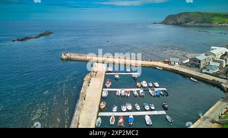 Gardenstown Aberdeenshire Écosse les murs du port amarrés les bateaux de pêche et la mer bleu vert à marée haute en été Crovie au loin Banque D'Images