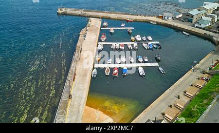 Gardenstown Aberdeenshire Écosse les murs du port amarraient les bateaux de pêche et la mer bleu vert à marée haute en été Banque D'Images