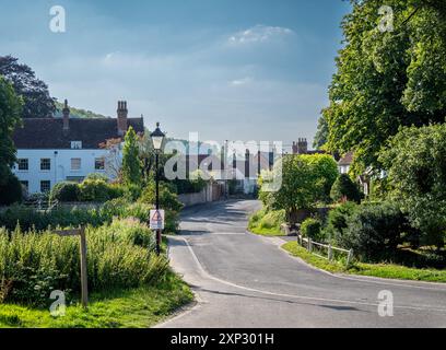 Une rue de village paisible à Buriton, Hampshire avec un panneau de limite de vitesse maximum de 20 km/h au premier plan. Banque D'Images